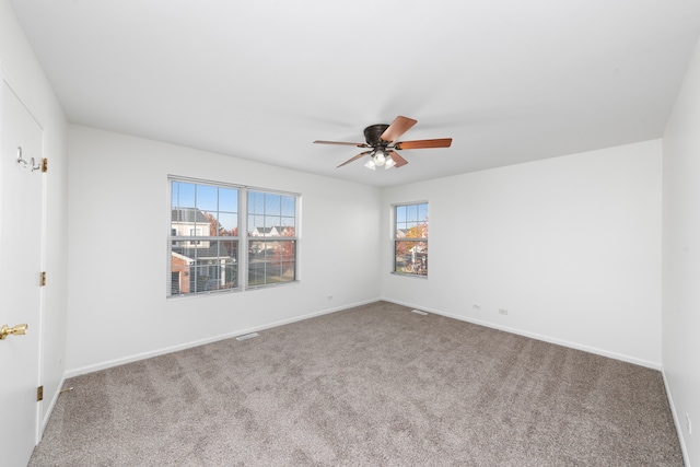 carpeted spare room featuring ceiling fan