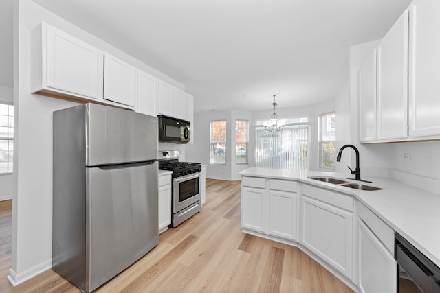 kitchen featuring white cabinetry, black appliances, sink, and light wood-type flooring