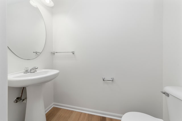 bathroom with sink, hardwood / wood-style flooring, and toilet