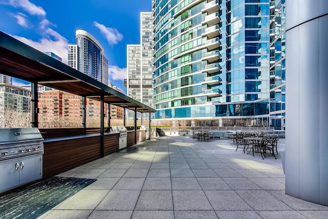 view of patio / terrace with a balcony, exterior kitchen, and a grill