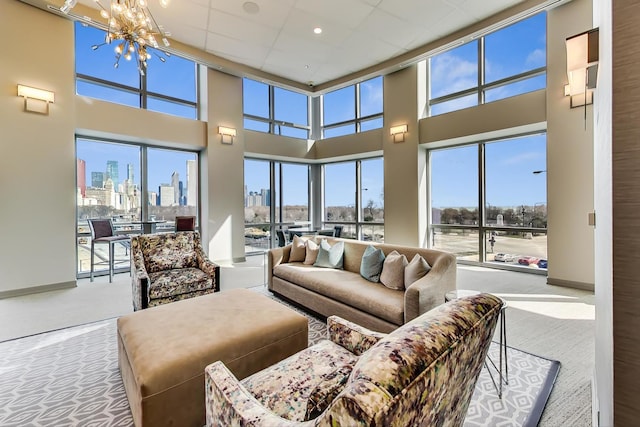 living room with a notable chandelier, carpet, and a high ceiling