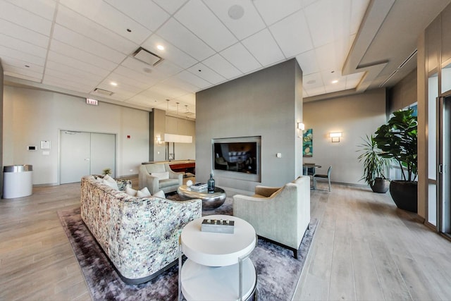 living room featuring light hardwood / wood-style floors and a drop ceiling