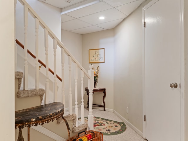 carpeted foyer entrance with a drop ceiling