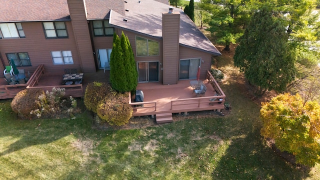 rear view of property featuring a lawn and a deck