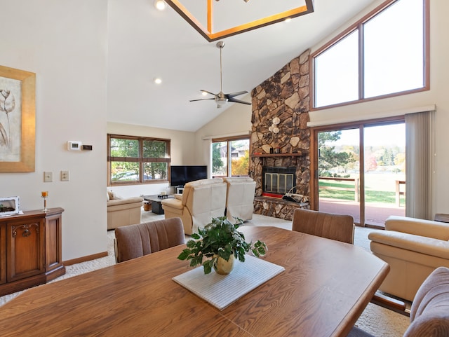 dining room featuring a fireplace, high vaulted ceiling, and ceiling fan