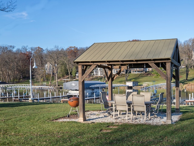 view of home's community featuring a yard, a water view, and a boat dock