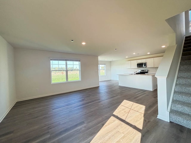 unfurnished living room with dark wood-type flooring