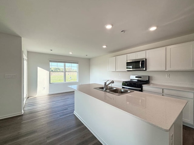 kitchen featuring appliances with stainless steel finishes, dark hardwood / wood-style floors, a kitchen island with sink, and sink