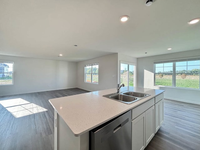 kitchen with white cabinetry, sink, dark wood-type flooring, stainless steel dishwasher, and a kitchen island with sink