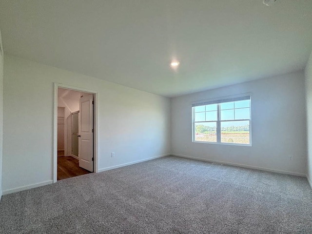 spare room featuring dark colored carpet