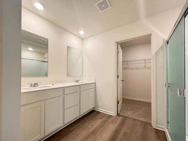 bathroom with hardwood / wood-style flooring, vanity, and an enclosed shower