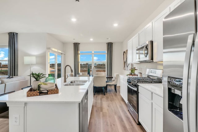 kitchen with sink, plenty of natural light, light hardwood / wood-style floors, and appliances with stainless steel finishes