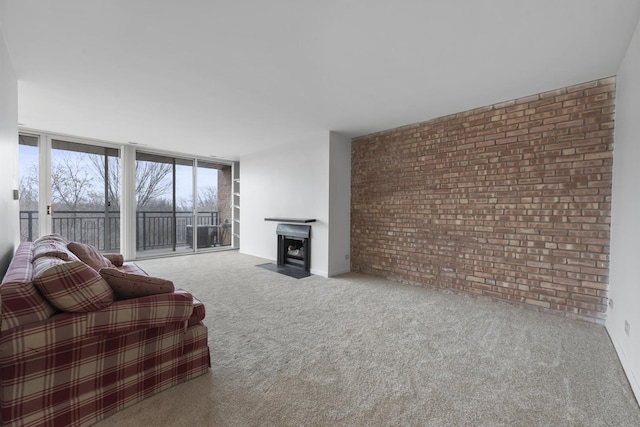 carpeted living room with floor to ceiling windows and brick wall