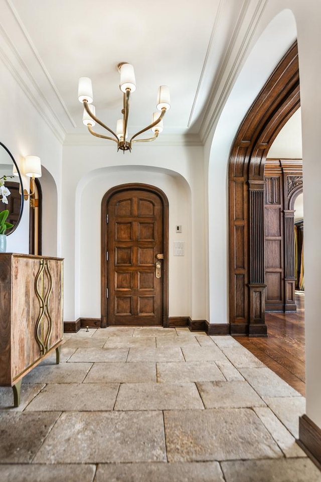 1320 N State Pkwy Unit 14-15Cd, Chicago, IL 60610 - foyer entrance with arched walkways, a chandelier, baseboards, crown molding, and stone tile flooring