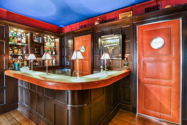 bar with wood-type flooring and sink