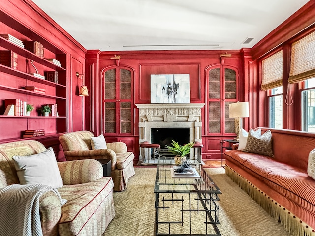 living room featuring ornamental molding and built in shelves