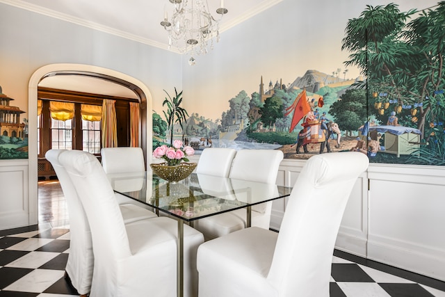 dining space with crown molding and an inviting chandelier