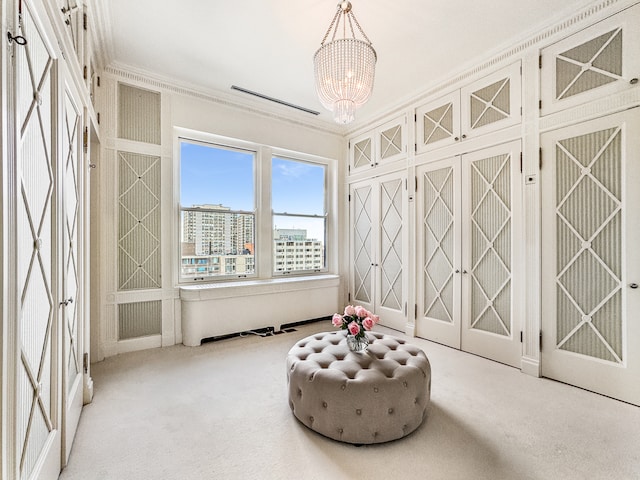 living area with light carpet, ornamental molding, and a chandelier