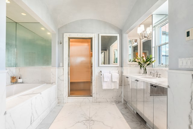 bathroom featuring vanity, a notable chandelier, tiled tub, and lofted ceiling