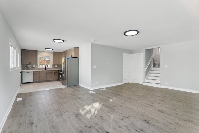 unfurnished living room with light hardwood / wood-style floors and sink