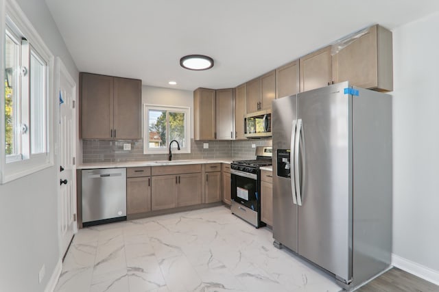 kitchen with appliances with stainless steel finishes, decorative backsplash, and sink