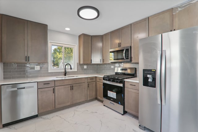 kitchen featuring decorative backsplash, stainless steel appliances, and sink