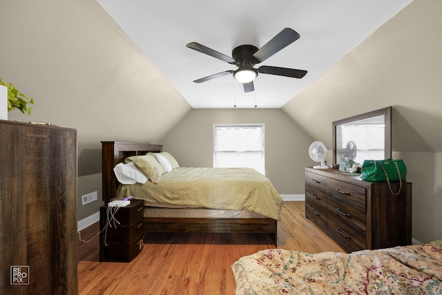 bedroom with ceiling fan, light hardwood / wood-style flooring, and vaulted ceiling