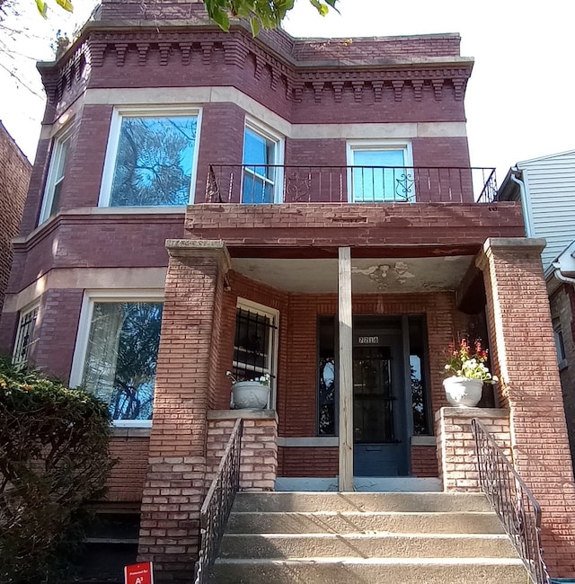 entrance to property featuring a balcony and a porch