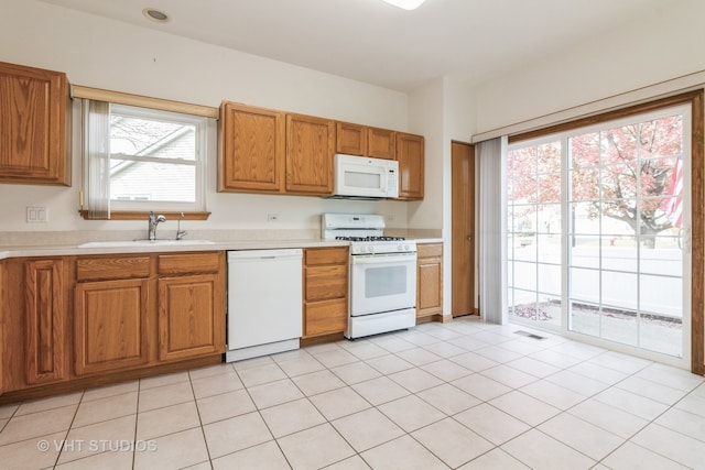 kitchen with white appliances, sink, and light tile patterned floors