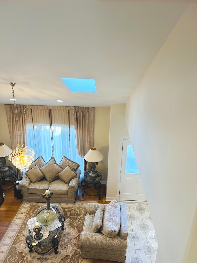 living room featuring light hardwood / wood-style flooring and a skylight