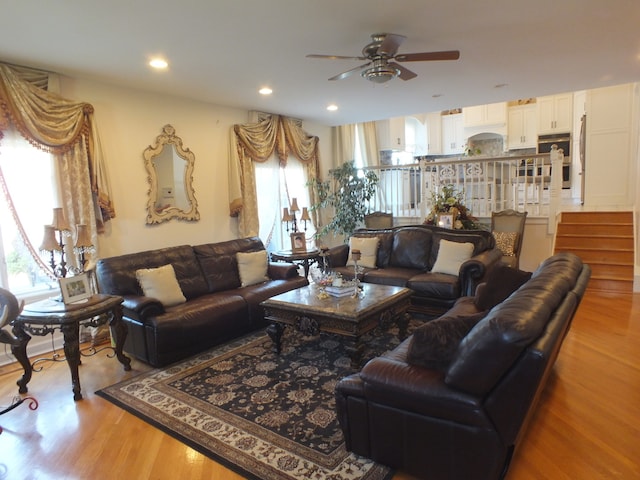 living room with ceiling fan and light wood-type flooring