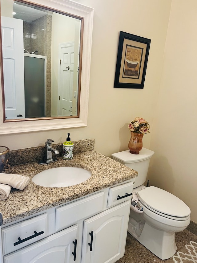 bathroom with vanity, toilet, and a tile shower