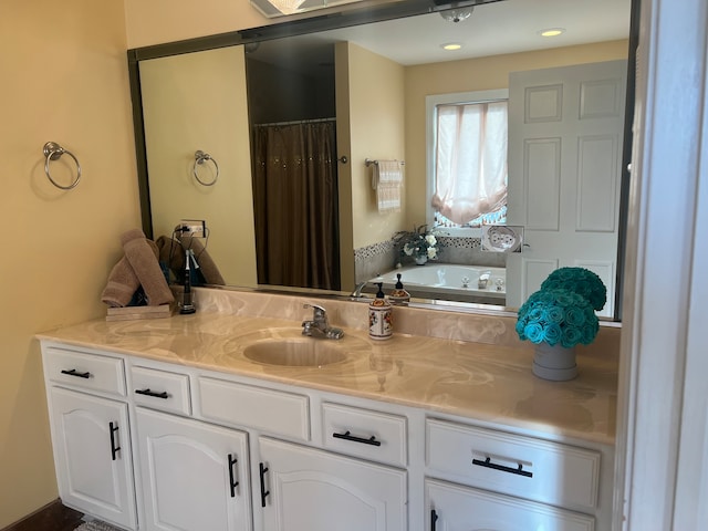 bathroom with vanity and a tub