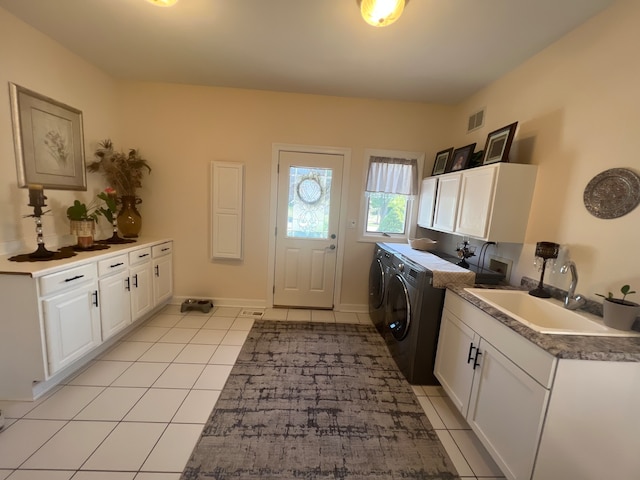 laundry area featuring cabinets, sink, washing machine and dryer, and light tile patterned floors