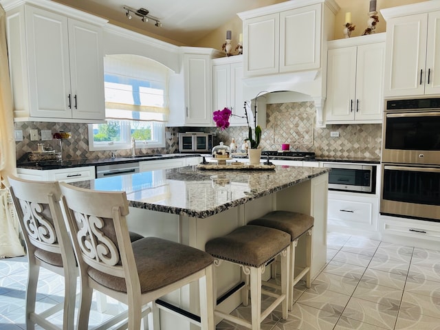 kitchen with white cabinetry, backsplash, and stainless steel appliances