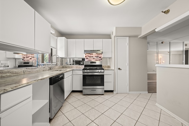 kitchen featuring stainless steel appliances, sink, light stone countertops, light tile patterned flooring, and white cabinets