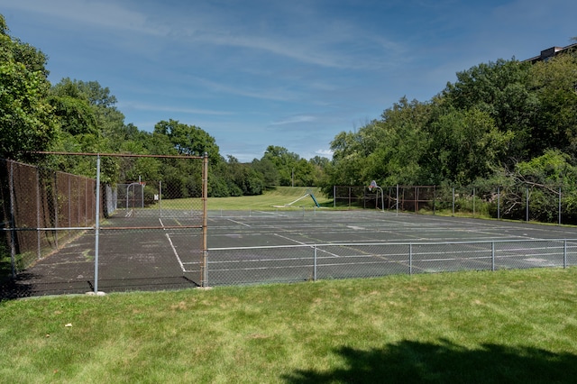 view of property's community with a yard and tennis court