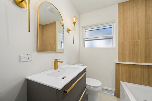 bathroom featuring vanity, toilet, and a tub