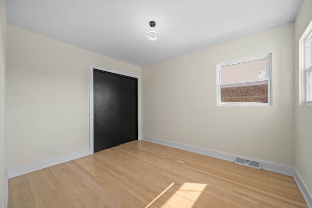 unfurnished bedroom with light hardwood / wood-style flooring and a closet