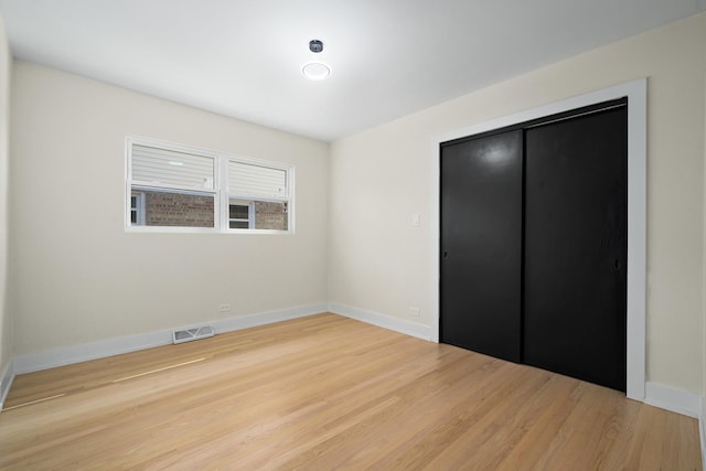 unfurnished bedroom with hardwood / wood-style floors and a closet