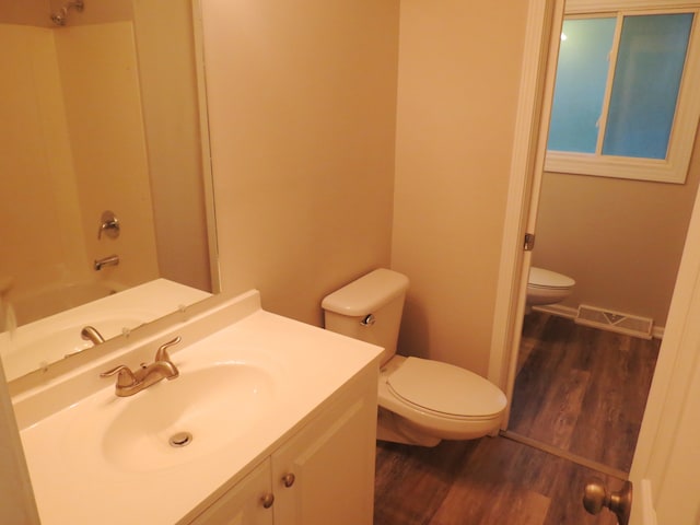 full bathroom featuring vanity, hardwood / wood-style flooring, toilet, and shower / bath combination