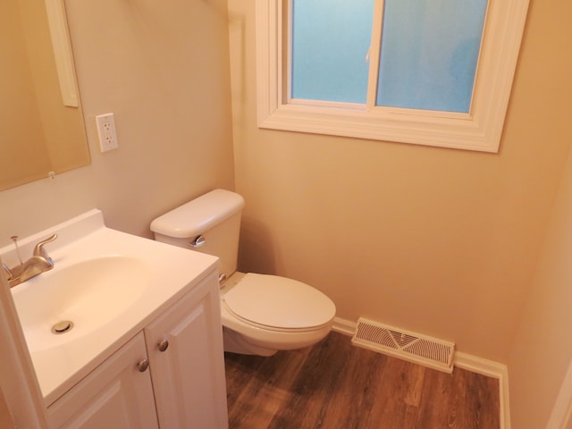 bathroom featuring toilet, vanity, and wood-type flooring