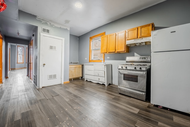 kitchen featuring dark hardwood / wood-style flooring, stainless steel range oven, and white refrigerator