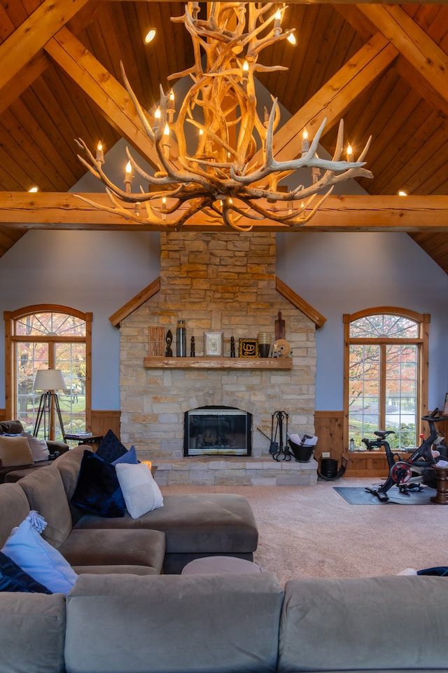 carpeted living room featuring beam ceiling, wooden ceiling, and a fireplace