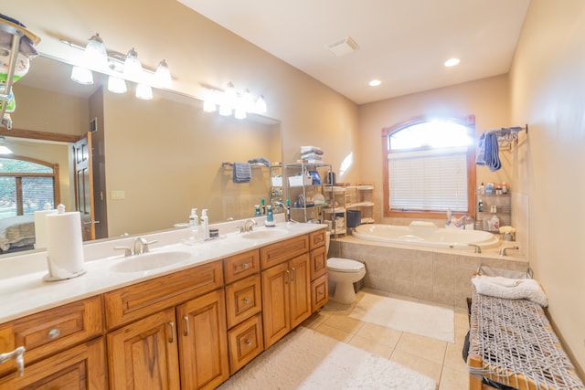 bathroom with vanity, tiled tub, plenty of natural light, and tile patterned floors