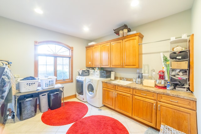 laundry area featuring sink, washer and dryer, light tile patterned floors, and cabinets