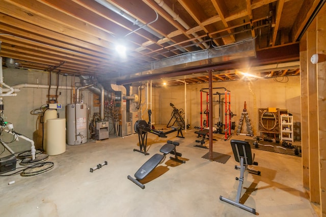 exercise room featuring concrete floors and water heater