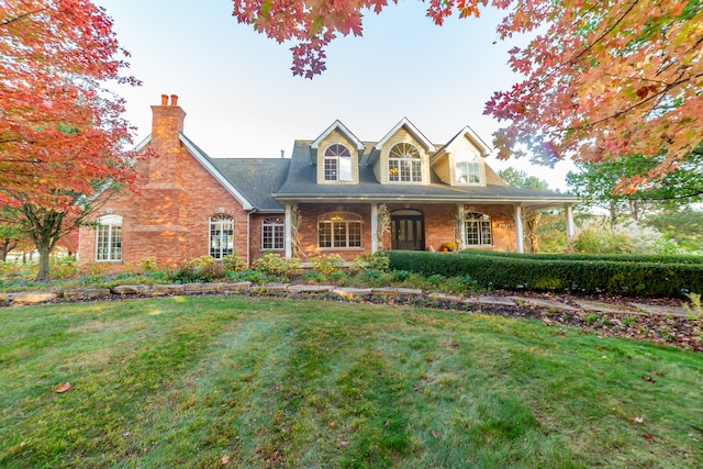 cape cod-style house featuring a lawn