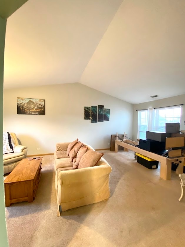 living room with vaulted ceiling and light colored carpet