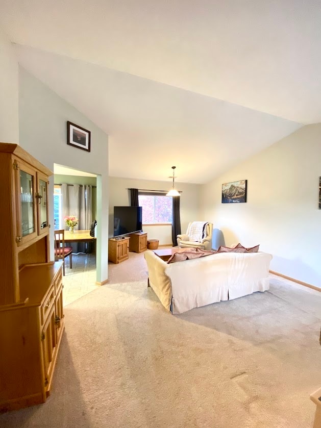 bedroom with vaulted ceiling and light colored carpet